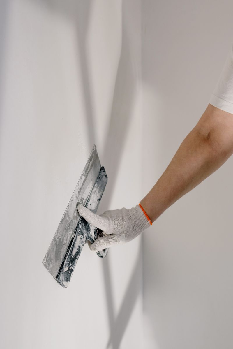 Estante de madera colocado en una pared clara con libros y objetos pequeños
